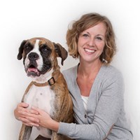 a woman smiling and hugging a dog